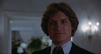 Movie still from “The Fury” (1978), directed by Brian De Palma – A person wearing a suit and tie; Close Up shot, Low angle