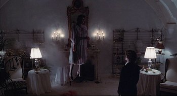 Movie still from “The Fury” (1978), directed by Brian De Palma – A woman standing in front of a mirror in a living room; Wide shot, Low angle