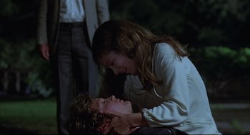 Movie still from “The Fury” (1978), directed by Brian De Palma – A woman and a young man are playing with each other in the dark; Medium shot, Over the shoulder angle
