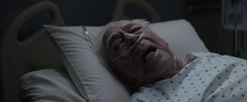 Movie still from “The Gambler” (2014), directed by Rupert Wyatt – An old man laying in a hospital bed with his mouth open; Close Up shot, Overhead angle