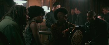 Movie still from “The Gambler” (2014), directed by Rupert Wyatt – A couple of women sitting next to each other in a room; Medium shot, Over the shoulder angle