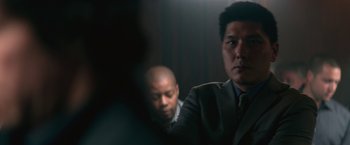 Movie still from “The Gambler” (2014), directed by Rupert Wyatt – Two men in suits and ties sitting in a darkened room; Close Up shot, Over the shoulder angle