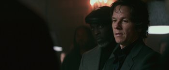 Movie still from “The Gambler” (2014), directed by Rupert Wyatt – A man in a black hat and a man in a gray suit; Close Up shot, Over the shoulder angle