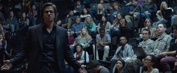 Movie still from “The Gambler” (2014), directed by Rupert Wyatt – A crowd of people sitting in front of a man in a black suit; Medium shot, High angle