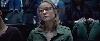 Movie still from “The Gambler” (2014), directed by Rupert Wyatt – A woman wearing glasses and a green jacket; Close Up shot, Over the shoulder angle