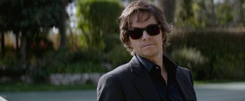 Movie still from “The Gambler” (2014), directed by Rupert Wyatt – A person wearing a suit and sunglasses; Close Up shot, Over the shoulder angle
