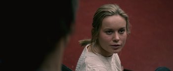 Movie still from “The Gambler” (2014), directed by Rupert Wyatt – A young woman in a white sweater is looking at the camera; Close Up shot, Over the shoulder angle