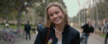 Movie still from “The Gambler” (2014), directed by Rupert Wyatt – A young woman is listening to music while walking down the street; Close Up shot, Over the shoulder angle