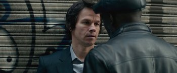 Movie still from “The Gambler” (2014), directed by Rupert Wyatt – A man wearing a suit and a leather jacket; Close Up shot, Over the shoulder angle