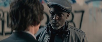 Movie still from “The Gambler” (2014), directed by Rupert Wyatt – A man wearing a hat and a leather jacket; Close Up shot, Over the shoulder angle