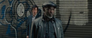 Movie still from “The Gambler” (2014), directed by Rupert Wyatt – A man in a leather jacket and a man in a black hat; Close Up shot, High angle