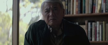 Movie still from “The Gambler” (2014), directed by Rupert Wyatt – An older man in a green jacket looking at the camera; Close Up shot, High angle