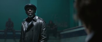 Movie still from “The Gambler” (2014), directed by Rupert Wyatt – A man wearing a leather jacket and hat; Medium shot, Low angle