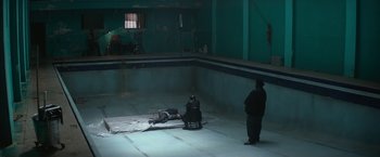 Movie still from “The Gambler” (2014), directed by Rupert Wyatt – A man sitting in a chair next to a pool; Extreme Wide shot, High angle