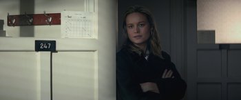 Movie still from “The Gambler” (2014), directed by Rupert Wyatt – A woman standing next to a wall with her arms crossed; Close Up shot, Over the shoulder angle