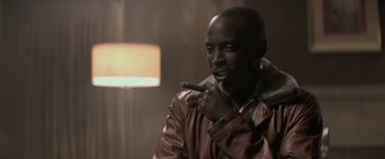 Movie still from “The Gambler” (2014), directed by Rupert Wyatt – A man smoking a cigar while wearing a leather jacket; Close Up shot, Low angle