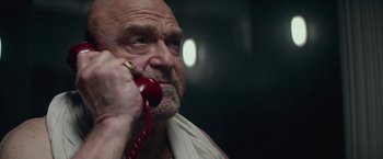 Movie still from “The Gambler” (2014), directed by Rupert Wyatt – An older man talking on a red phone; Close Up shot, Low angle
