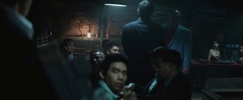 Movie still from “The Gambler” (2014), directed by Rupert Wyatt – A group of people sitting in a room; Medium shot, Over the shoulder angle