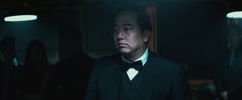 Movie still from “The Gambler” (2014), directed by Rupert Wyatt – A man in a suit and bow tie looking sad; Close Up shot, Low angle