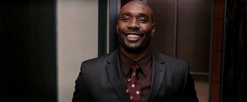 Movie still from “The Game Plan” (2007), directed by Andy Fickman – A man in a suit and tie smiling for the camera; Close Up shot, Over the shoulder angle