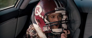Movie still from “The Game Plan” (2007), directed by Andy Fickman – A young girl wearing a football helmet in a car; Close Up shot, Low angle