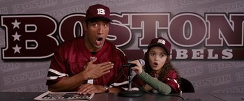 Movie still from “The Game Plan” (2007), directed by Andy Fickman – A man and a little girl are sitting at a microphone; Medium shot, High angle