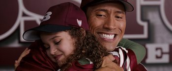 Movie still from “The Game Plan” (2007), directed by Andy Fickman – A man and a little girl are smiling for the camera; Close Up shot, Over the shoulder angle
