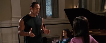 Movie still from “The Game Plan” (2007), directed by Andy Fickman – A group of people sitting in a living room; Medium shot, Over the shoulder angle