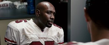 Movie still from “The Game Plan” (2007), directed by Andy Fickman – A person wearing a football uniform; Close Up shot, Over the shoulder angle