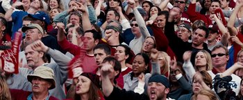 Movie still from “The Game Plan” (2007), directed by Andy Fickman – A group of people in a stadium with their hands raised; Medium shot, High angle