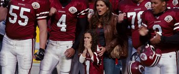 Movie still from “The Game Plan” (2007), directed by Andy Fickman – A woman and a girl are crying while a football player watches; Medium shot, High angle