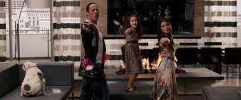 Movie still from “The Game Plan” (2007), directed by Andy Fickman – A man and two girls are dancing in front of a fireplace; Medium shot, High angle