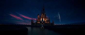 A castle lit up at night by the water