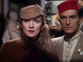 Movie still from “The Garden of Allah” (1936), directed by Richard Boleslawski – A man and a woman wearing hats in a movie scene; Close Up shot, Low angle