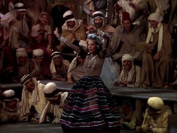 Movie still from “The Garden of Allah” (1936), directed by Richard Boleslawski – A woman is performing a dance in front of an audience; Wide shot, High angle