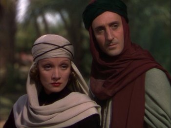 Movie still from “The Garden of Allah” (1936), directed by Richard Boleslawski – A man and a woman standing next to each other; Close Up shot, Low angle