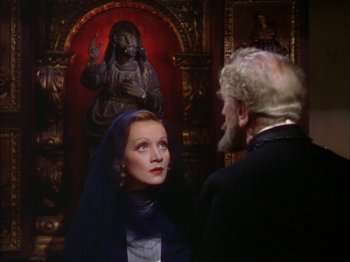 Movie still from “The Garden of Allah” (1936), directed by Richard Boleslawski – A man and a woman standing next to each other in front of a painting; Medium shot, Over the shoulder angle