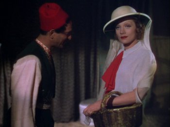 Movie still from “The Garden of Allah” (1936), directed by Richard Boleslawski – A man and a woman in a hat and a basket; Medium shot, High angle