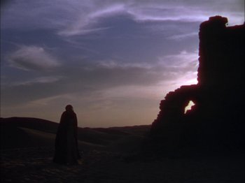 Movie still from “The Garden of Allah” (1936), directed by Richard Boleslawski – A person standing in front of a castle at night; Extreme Wide shot, Low angle