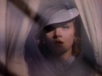 Movie still from “The Garden of Allah” (1936), directed by Richard Boleslawski – A woman wearing a white hat looking into a mirror; Close Up shot, Low angle