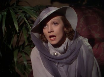 Movie still from “The Garden of Allah” (1936), directed by Richard Boleslawski – A woman wearing a white hat and a scarf; Close Up shot, Over the shoulder angle