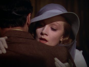 Movie still from “The Garden of Allah” (1936), directed by Richard Boleslawski – A man and a woman embracing each other in front of a curtain; Close Up shot, Over the shoulder angle