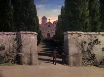 Movie still from “The Garden of Allah” (1936), directed by Richard Boleslawski – A man standing in front of a church with trees; Extreme Wide shot, High angle