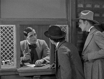 Movie still from “The General” (1926), directed by Buster Keaton – A man in a suit and tie looking at another man in a suit and tie; Medium shot, Over the shoulder angle