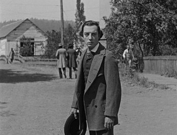 Movie still from “The General” (1926), directed by Buster Keaton – A black and white photo of a man in a suit and hat; Medium shot, Low angle