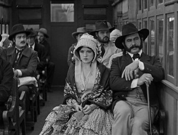 Movie still from “The General” (1926), directed by Buster Keaton – A group of people sitting on a train; Medium shot, High angle