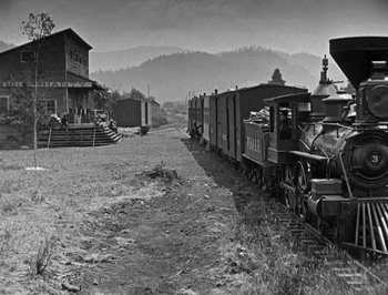 Movie still from “The General” (1926), directed by Buster Keaton – An old train is traveling down the train tracks; Extreme Wide shot, Low angle