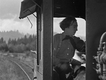 Movie still from “The General” (1926), directed by Buster Keaton – An old black and white photo of a person on a train; Medium shot, Low angle