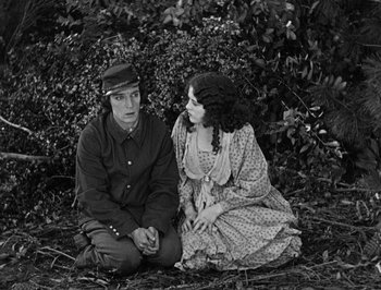 Movie still from “The General” (1926), directed by Buster Keaton – A man and a woman sitting on the ground; Medium shot, High angle