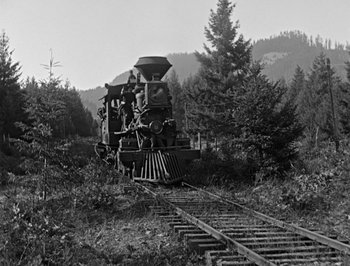 Movie still from “The General” (1926), directed by Buster Keaton – An old steam engine train traveling through the woods; Extreme Wide shot, Low angle